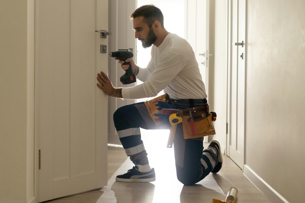 Portrait Young Male Carpenter Repairing Door Lock